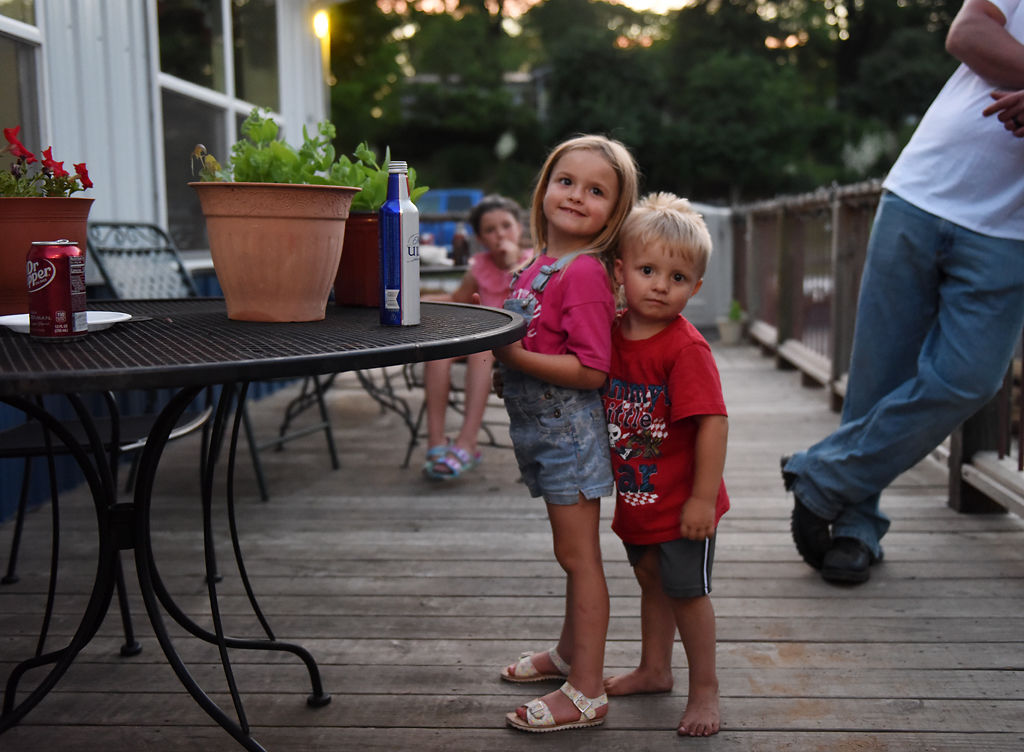 Gavin Vaughn, 2, hugs his sister Kinslee, 5, on Friday on the porch of American Veterans Post #153